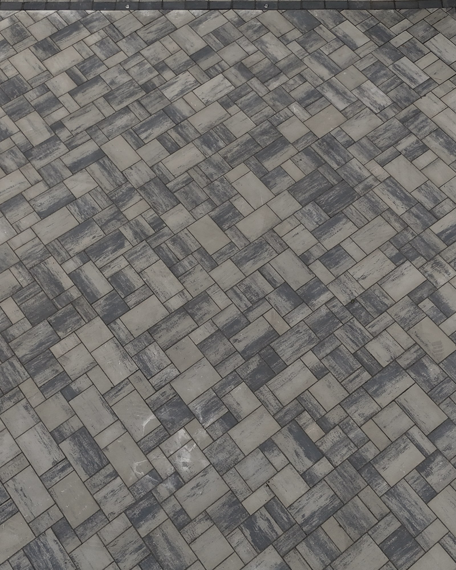 Close detail of interlocking pavers arranged in a mixed rectangular pattern